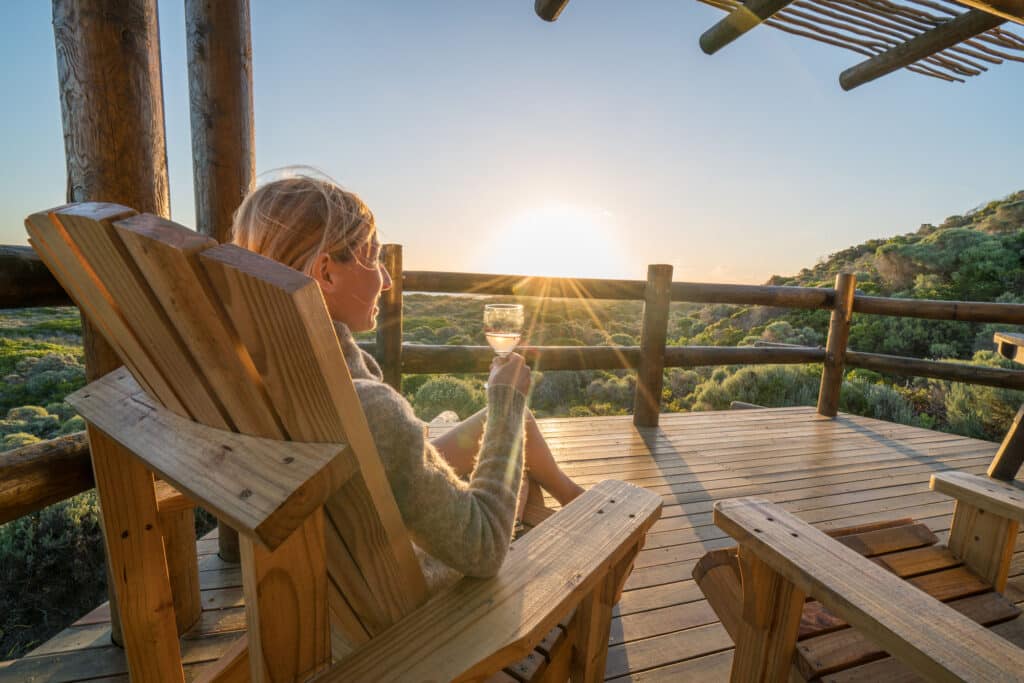 Young woman relaxing on terrace at sunset